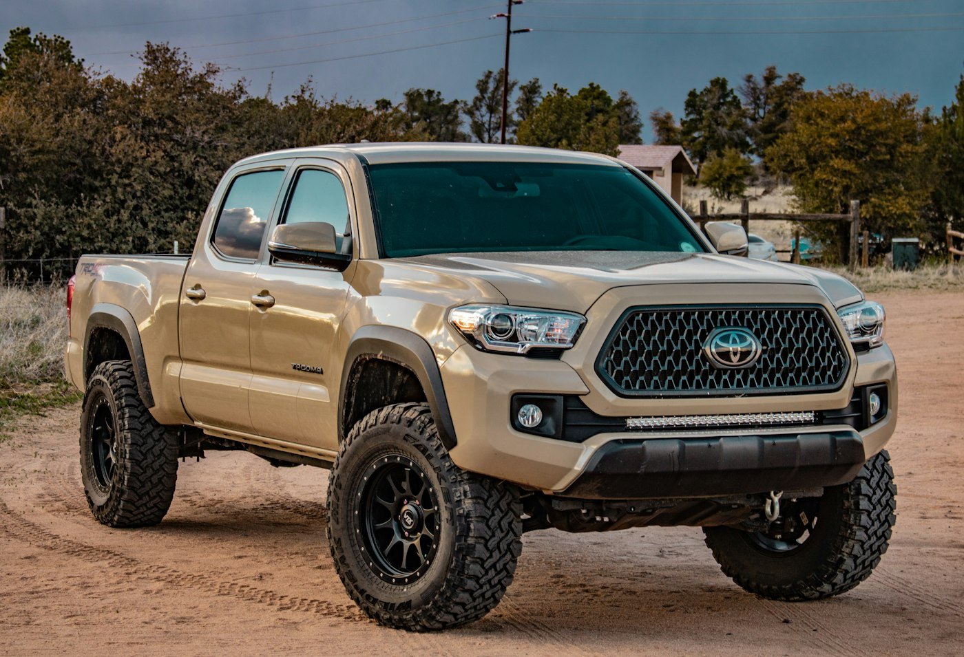 Lifted pickup truck with aftermarket wheels on a dirt road