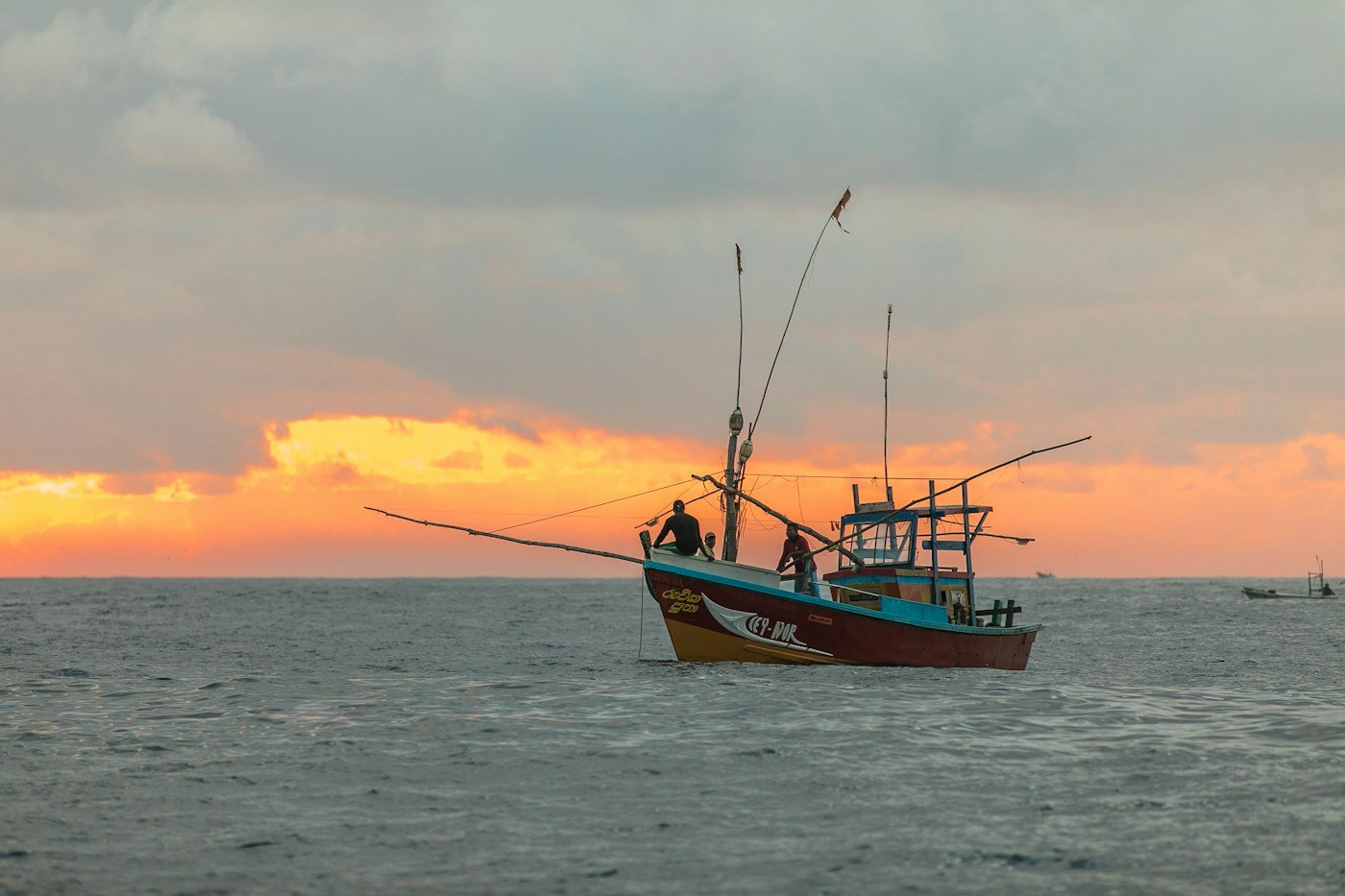 Fishing boat on open water at sunset